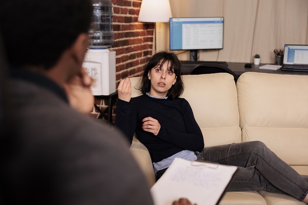 Unhappy woman laying on sofa at psychotherapy session